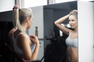 sporty-woman-looking-at-herself-in-the-mirror_1153-954