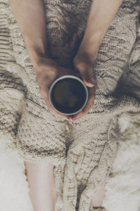 woman-hands-holding-tasty-warm-coffee-espresso-in-ceramic-cup-sitting-on-bed-with-plaid-home-concept-top-view_1220-1821